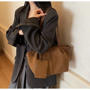 Detail of dark brown vintage suede tote bag with matching zippered pouch and side straps