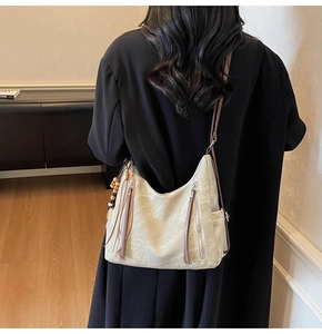Detail of hobo bag with retro wood beads and woven tassel on premium leather finish
