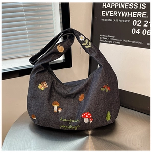 Détail de broderie de champignons et escargots sur sac hobo en jean gris foncé