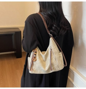 Detail view of the beige hobo bag with ethnic fringe tassel and brown leather shoulder strap
