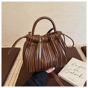 Close-up of pleated dark brown bucket bag with textured PU leather and drawstring detail