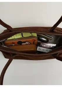 Macro top view of dark brown suede tote bag showing its large internal storage space