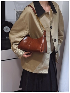 Brown glossy leather shoulder bag with gold chain strap in a retro minimalist style