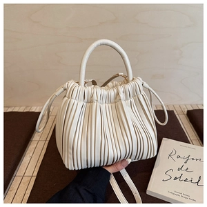 Close-up of cream white pleated bucket bag with fine faux leather texture and gold hardware