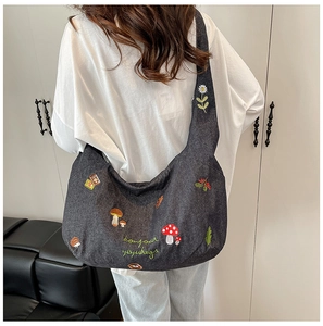 Détails de broderie de champignons et hérissons sur un sac fourre-tout gris foncé