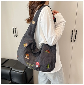 Détail de la broderie champignon et bonjour sur un grand sac en toile gris foncé