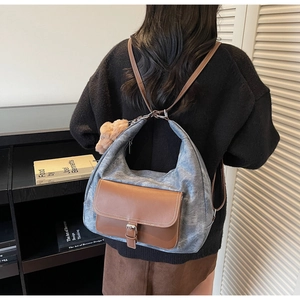 Vista posteriore di una modella con lo zaino vintage in pelle grigia e marrone con charm