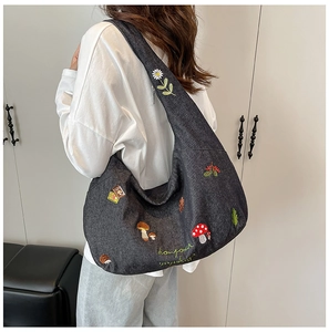 Détail de motifs forestiers brodés avec hérissons et champignons sur un sac denim