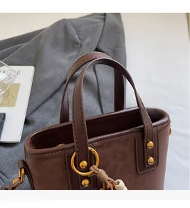 Detail of comfortable faux leather handles and gold hardware on leopard bucket bag