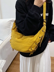 Bright yellow crescent crossbody bag with stylish side lace-up details and long strap