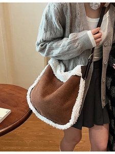 Brown faux suede crossbody bag with white faux fur trim and adjustable leather strap