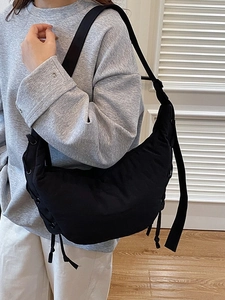 Classic black crescent shoulder bag with side tie details and adjustable wide strap