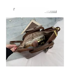 Vista dall'alto della borsa marrone a trama con tasche interne e spazio per accessori