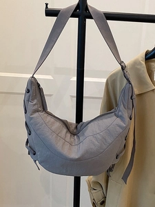 Minimalist grey nylon crescent bag with adjustable strap and side drawstring detail