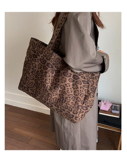 Détail d'un grand sac cabas à imprimé léopard porté à l'épaule par un mannequin