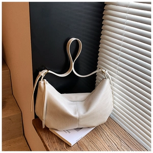 Detail of cream PU leather dumpling bag showing vertical stitching and metal zipper
