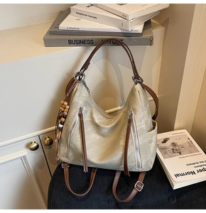 Detail of vintage canvas tote with leather straps, metallic zippers, and beaded charm
