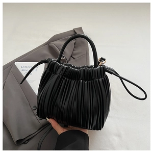 Detail of black pleated cloud bucket bag with textured leather and detachable strap