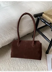 Detail of a large brown suede shoulder bag in a stylish minimalist room setting
