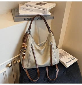 Detail of vintage khaki two-way hobo bag with textured finish and colorful wood bead charm
