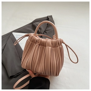 Detail of soft pleated shoulder bag in dusty rose with fine vertical gathers and slim strap