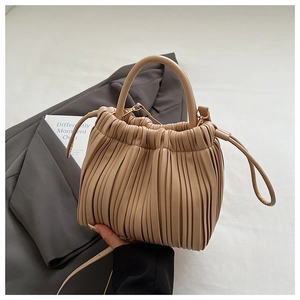 Detailed view of beige pleated bucket bag featuring drawstring closure and soft PU leather