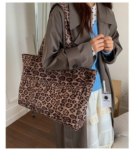 Détail d'un grand sac cabas à motif léopard porté avec un manteau d'automne élégant