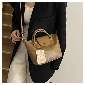 Borsa tote marrone a trama intrecciata con doppi manici e tracolla indossata da modella