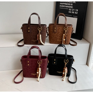 Collection of textured bucket bags in four colors with rivet details and beaded tassels