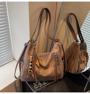 Close-up of brown vintage hobo bag with colorful beads, wooden ring and leather tassels