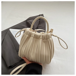 Macro shot of off-white pleated texture and vegan leather detail on the stylish bucket bag