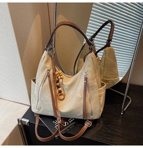 Detail of khaki frosted leather hobo bag with wooden bead tassels and side zip pockets