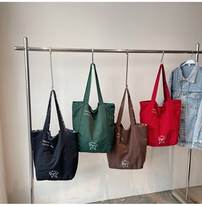 Detail of four colorful canvas tote bags featuring cute cartoon dog and text prints