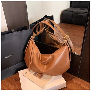 Detailed view of a vintage brown leather crescent hobo bag with adjustable gold buckle strap