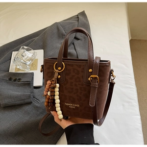 Detail of leopard print bucket bag with wood bead tassel and vintage metal hardware