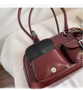 Detail of vintage deep red glossy patent leather handbag with silver metallic buckle