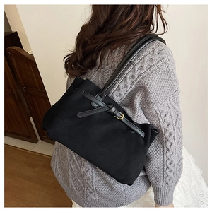 Dettaglio borsa tote in pelle scamosciata nera con tracolla in pelle e fibbia dorata