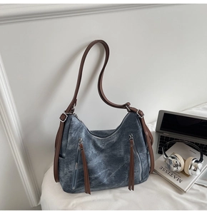 Detail of grey washed Hobo bag with brown leather straps and front vertical zippers