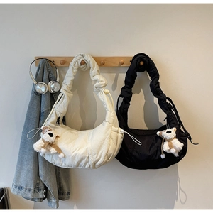 Detail view of stylish cloud bags with ruched straps and cute plush bear charm