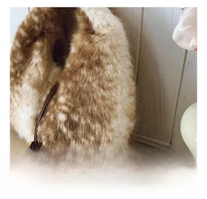 Detailed close-up of brown and white faux fur bag with a gold ball charm and slim strap