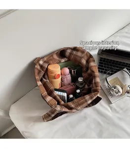 Detailed view of the spacious interior of the brown plaid tote bag with everyday items