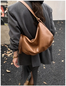 Close-up of caramel brown leather tote bag with soft texture on a fashion model