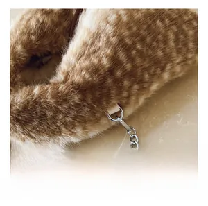 Close-up of smooth metal zipper and soft leopard faux fur texture on the fashion handbag