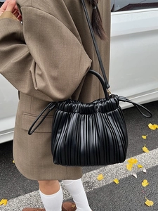 Pleated black leather bucket bag with drawstring closure and crossbody strap