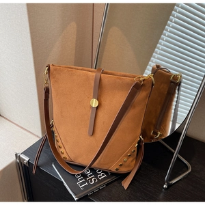 Detail view of brown faux suede tote bag with golden studs and leather strap decoration