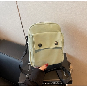 Dettaglio della borsa a tracolla in nylon verde menta con fibbie nere e cinghia regolabile