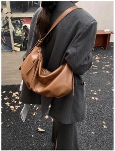Brown retro hobo bag shown in a model autumn street style outfit with vintage leather details