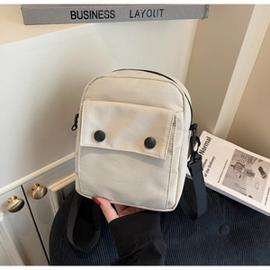 Dettaglio della mini borsa a tracolla bianco sporco con fibbie doppie e cinturino nero