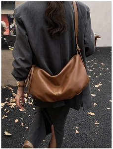 Close-up of brown matte leather hobo bag showing natural pleats and adjustable strap