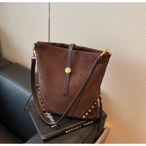 Brown faux suede shoulder bag with gold studs and round buckle in a boho style